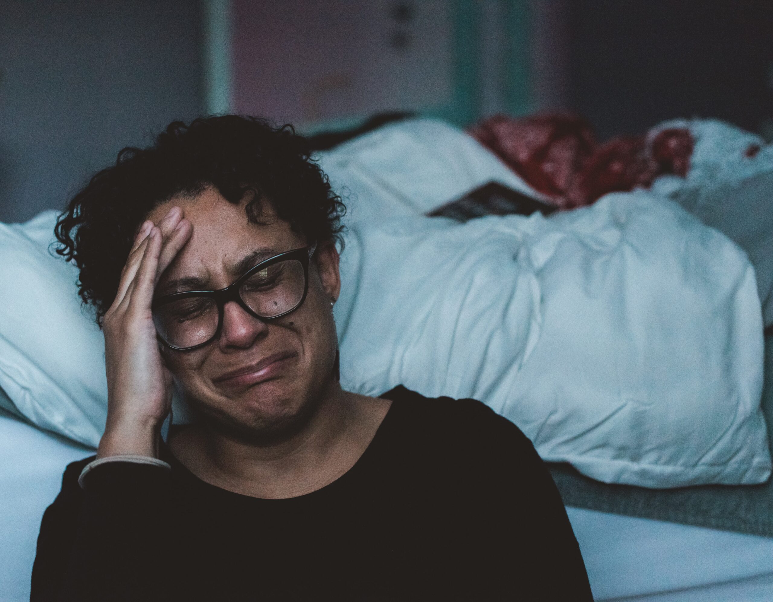 woman crying by bed