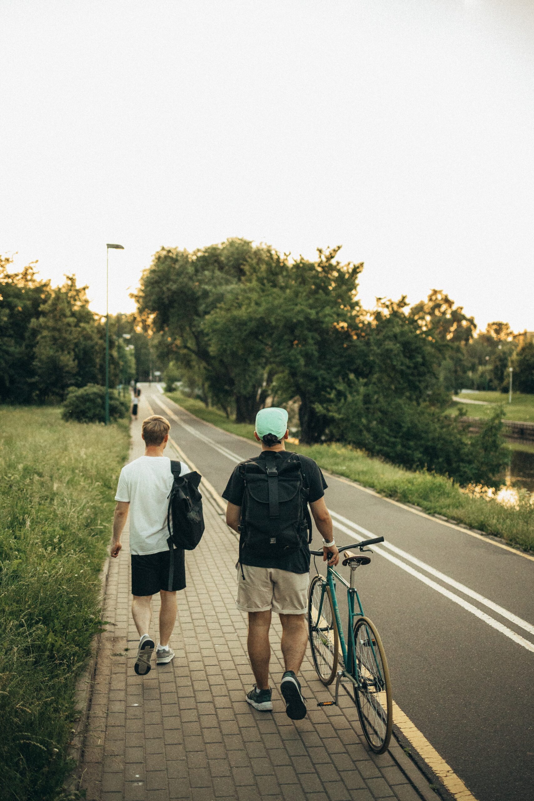 Two men walking with bike