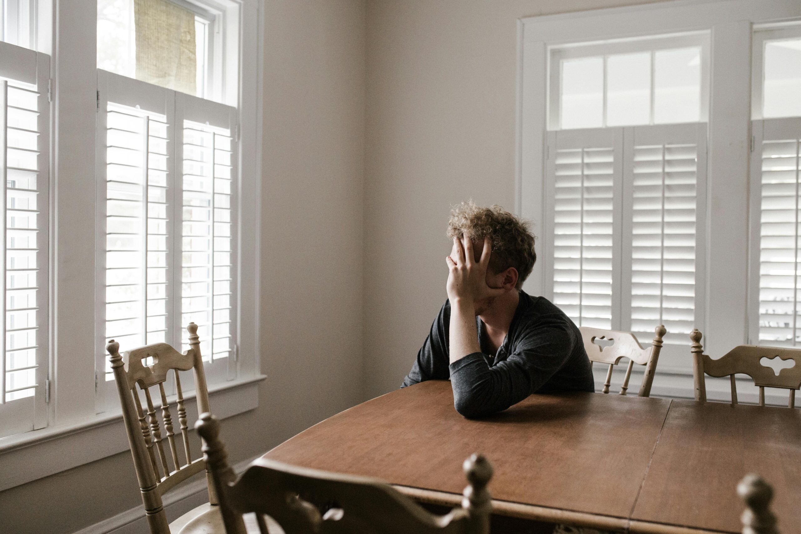 sad man sitting alone at dining room table