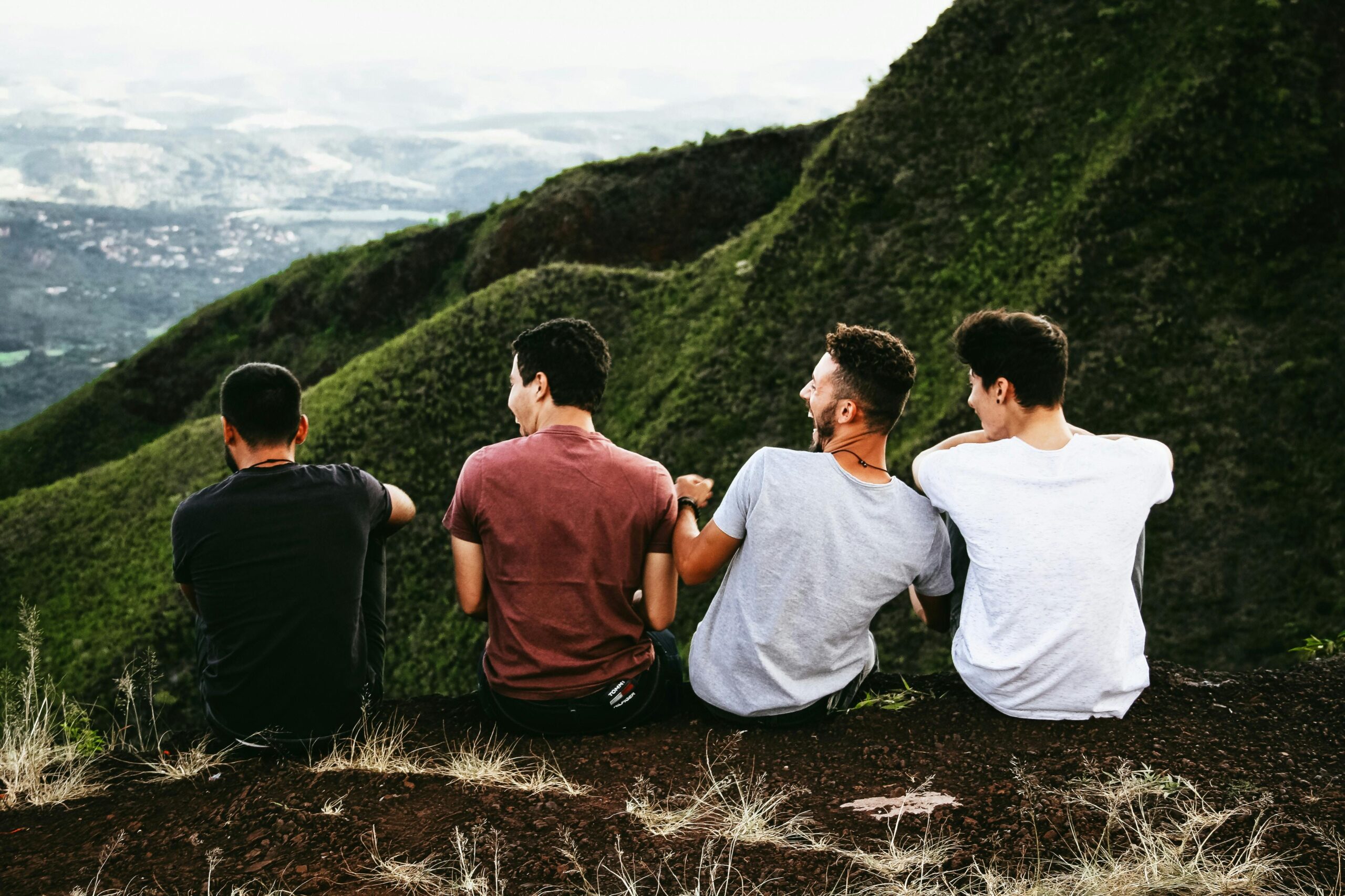 Male friends laughing together on a mountain top