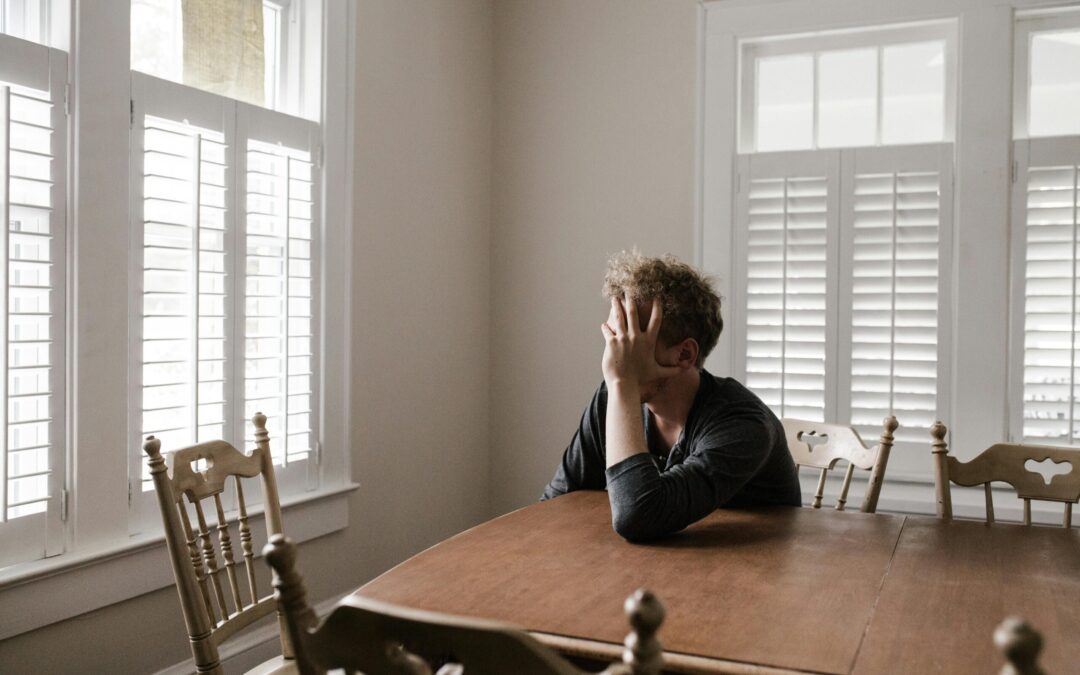 sad man sitting alone at dining room table